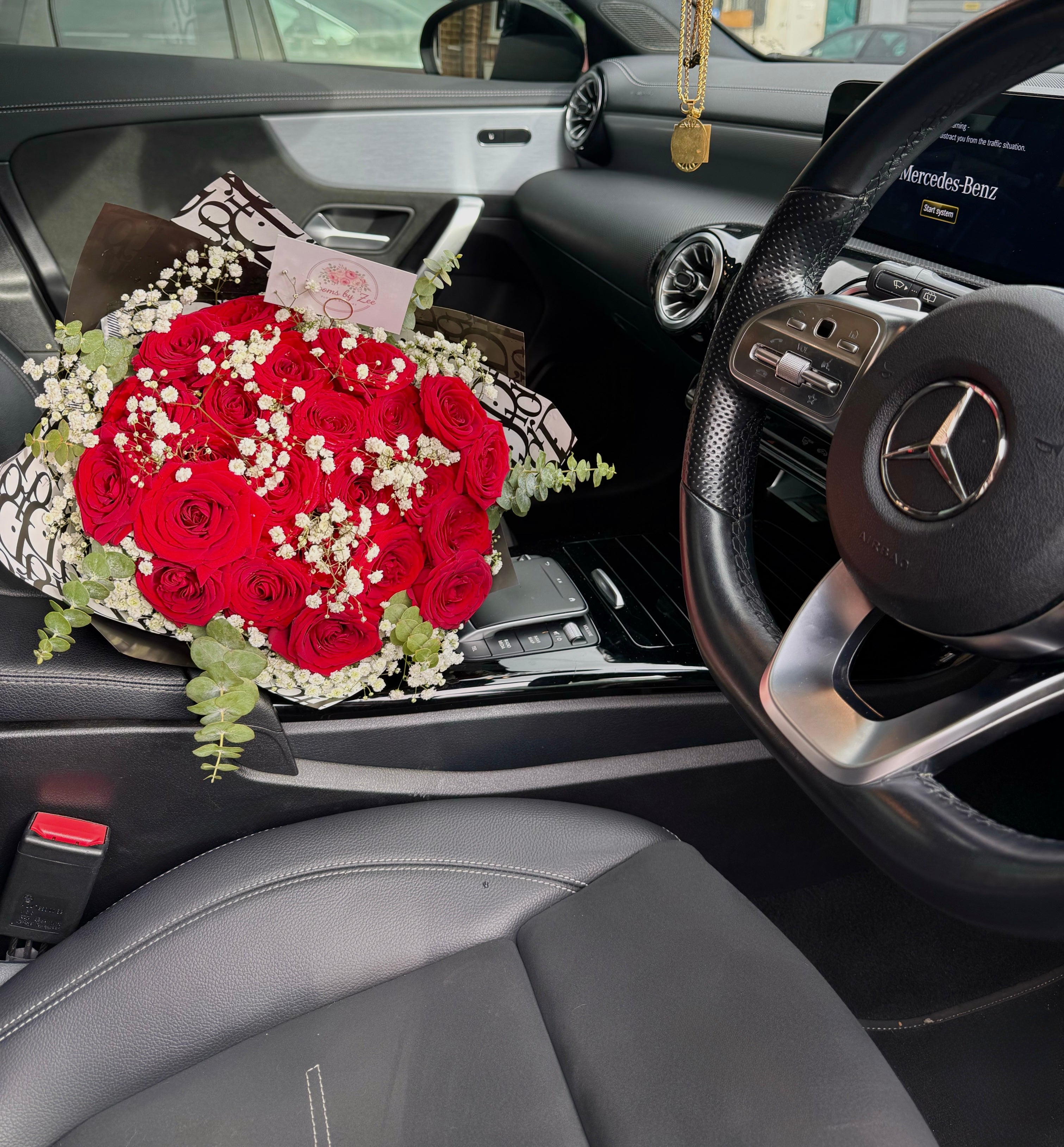 Medium red rose bouquet with filler gyps and branded wrapping paper.